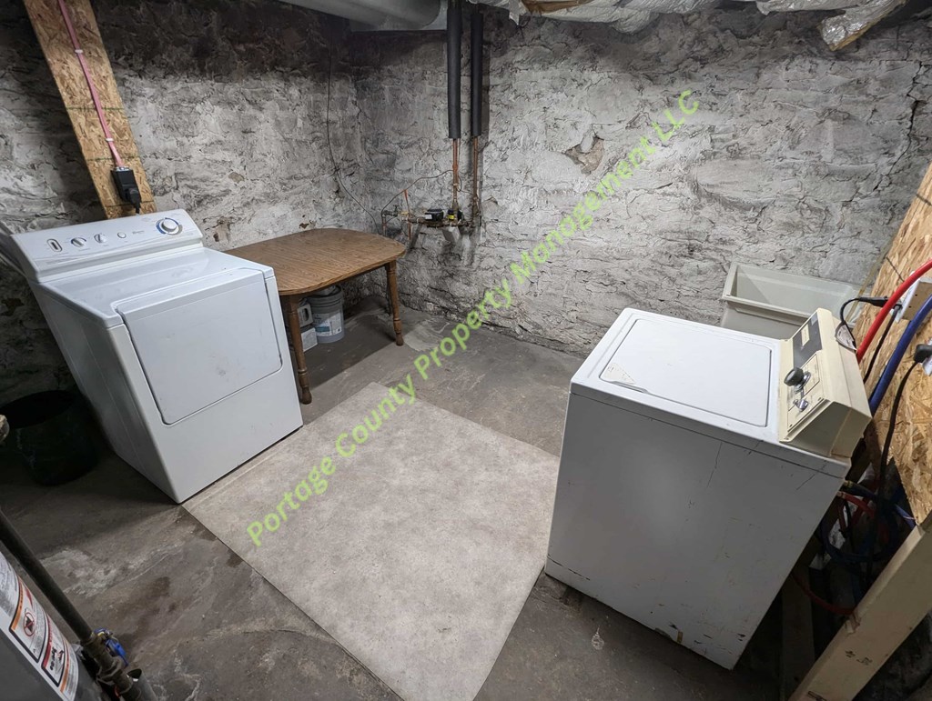 A dirty basement with a washer and dryer.
