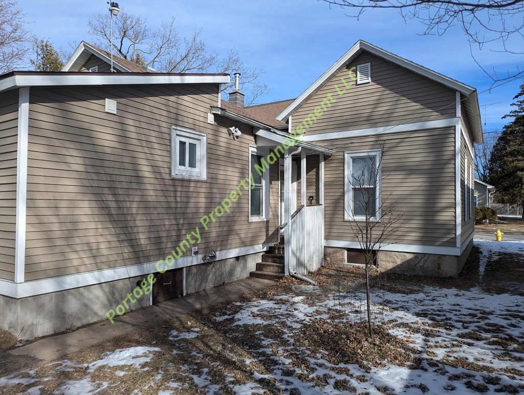 A house with a brown siding and a white door is shown.