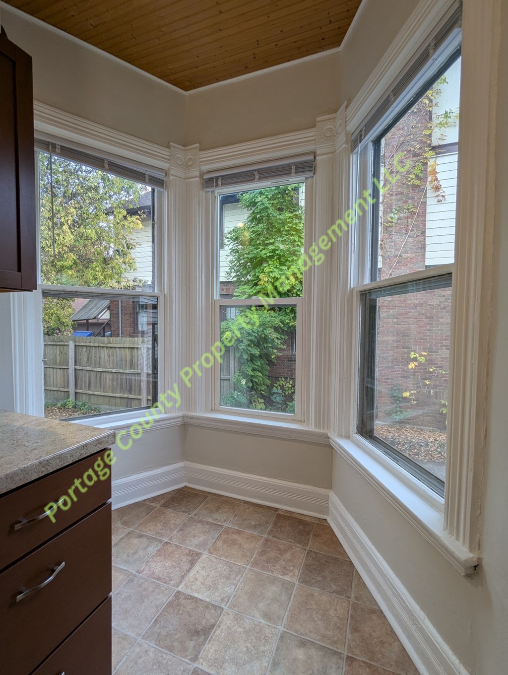 A sunny room with a window overlooking a backyard.
