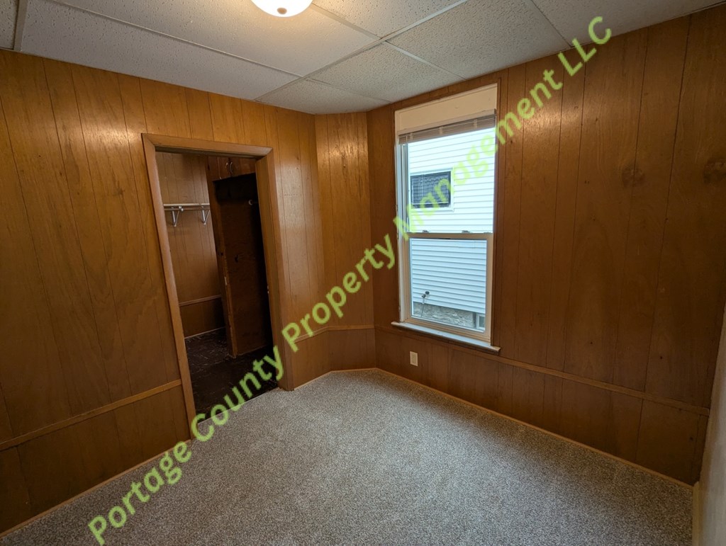 A room with wooden walls and a carpeted floor.