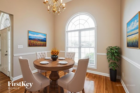 A dining room with a wooden table and chairs.