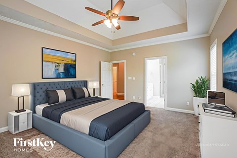 A bedroom with a large bed and a ceiling fan.