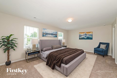 A bedroom with a large bed and a blue chair.