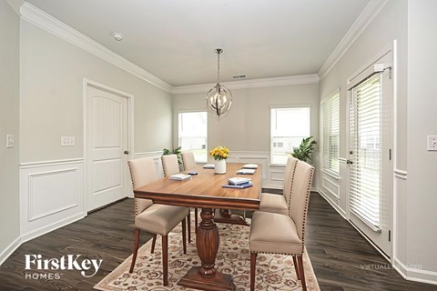 A dining room with a wooden table and chairs.