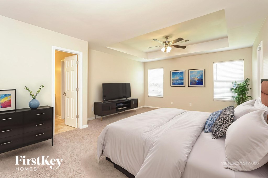 A bedroom with a bed, dresser, and television.