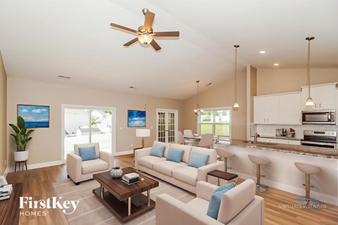 A living room with a white couch and a ceiling fan.