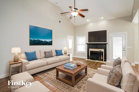 A living room with a fireplace and a painting on the wall.
