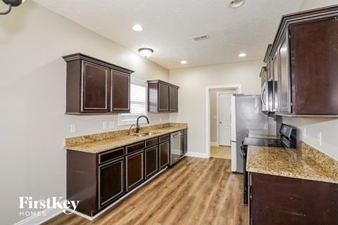 A kitchen with wooden cabinets and a granite countertop.