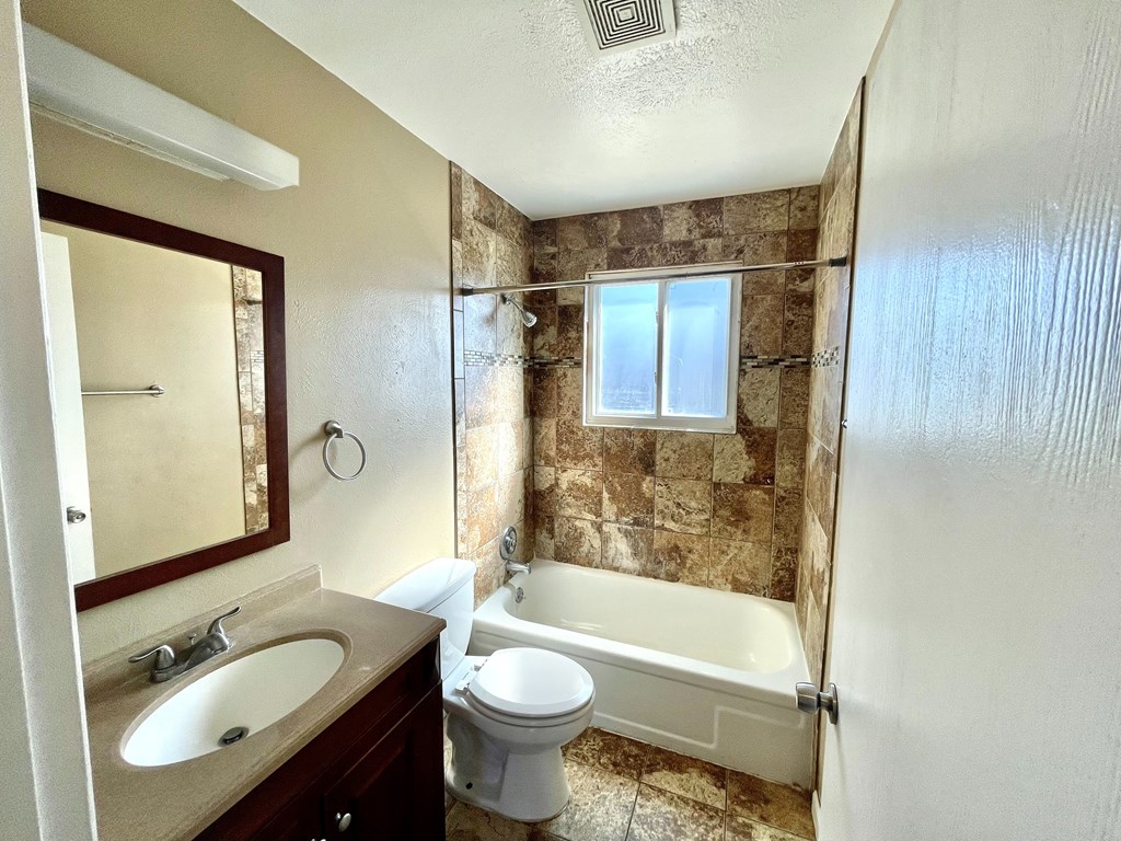 A bathroom with a toilet, sink, and bathtub.