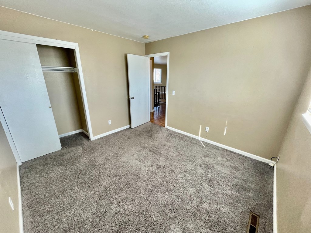 A room with a carpeted floor and a white door.