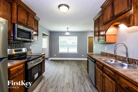 A kitchen with wooden cabinets and a stainless steel refrigerator.