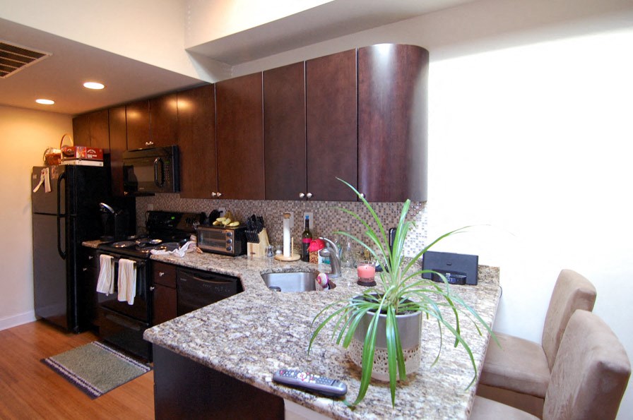 a kitchen with wooden cabinets and a granite counter top