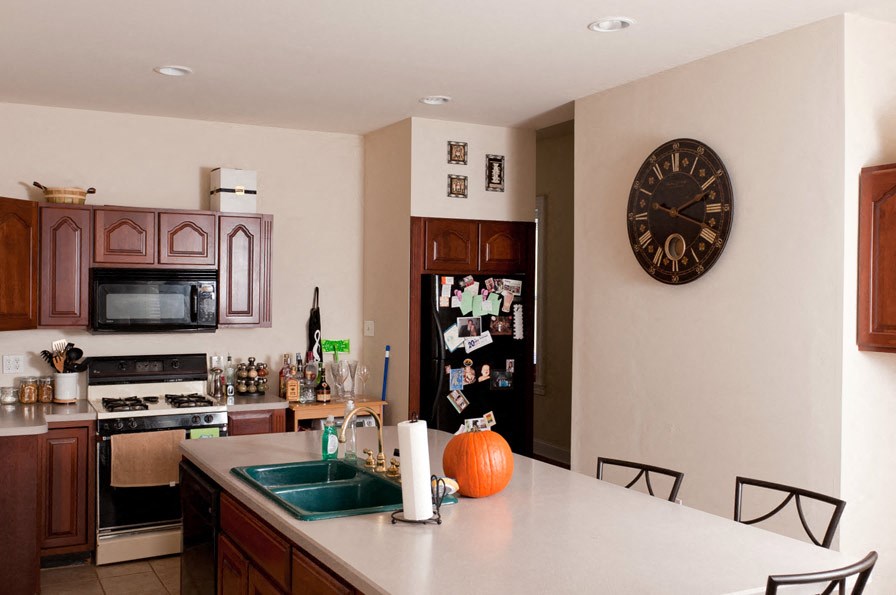 a kitchen with a counter and a clock on the wall