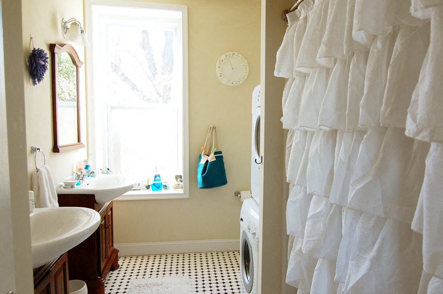 a bathroom with a sink and a washing machine     and a window