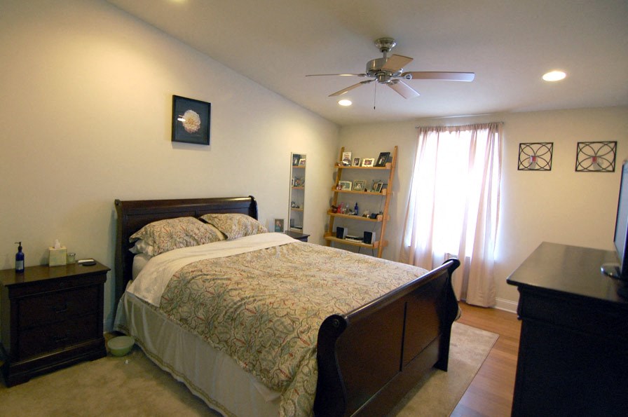 a bedroom with a bed and a ceiling fan