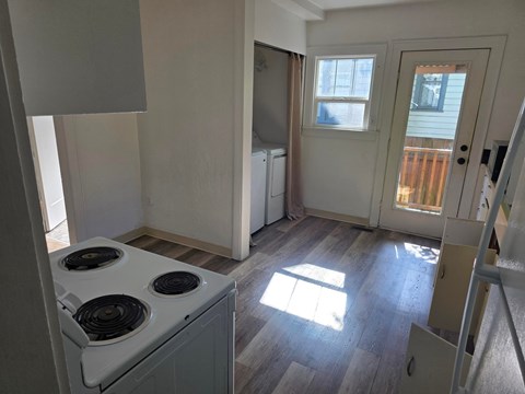 A kitchen with a stove top oven and a window.