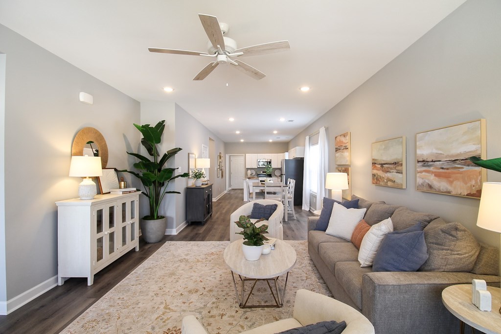 A well-lit, modern living room with a variety of furniture and decor.