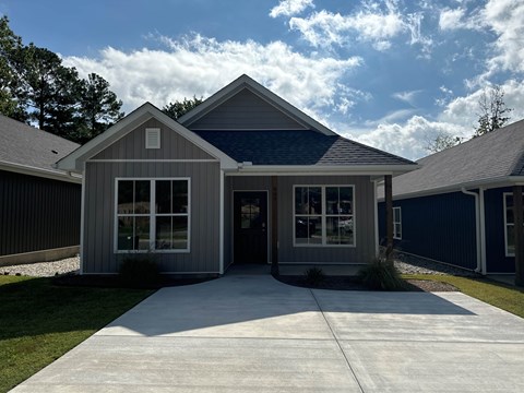 A house with a grey roof and a blue sky in the background.
