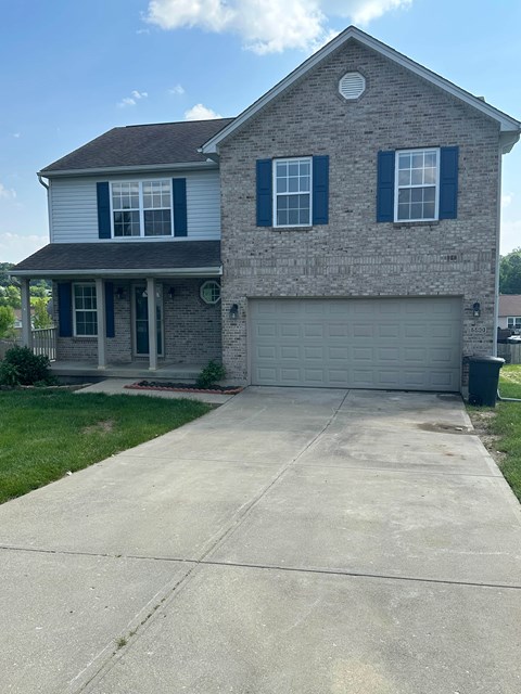 A two-story house with a garage and a driveway.