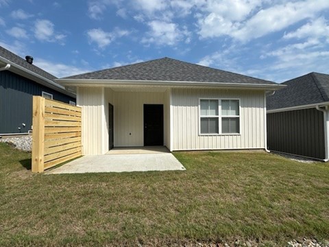 A house with a grey roof and a wooden fence.