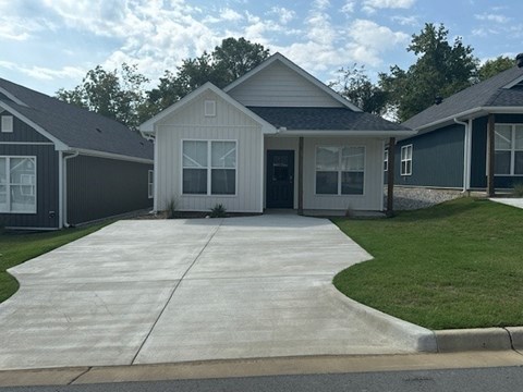 A house with a grey roof and a white garage door.