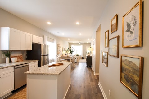 A kitchen with a white counter top and white cabinets.