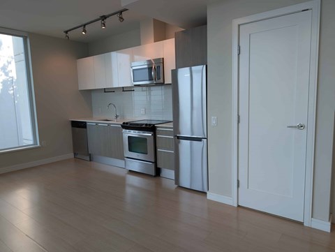 A kitchen with white cabinets and stainless steel appliances.