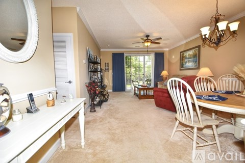 A living room with a white table and chairs, a mirror, and a ceiling fan.