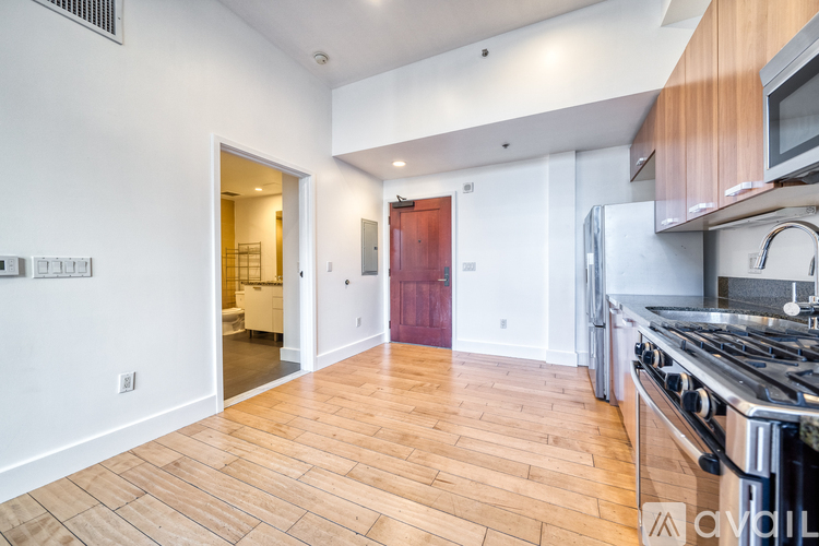 A kitchen with a stove top oven and wooden floors.