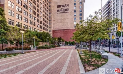 A long brick walkway leads to a building with a sign that says Rowan Building.