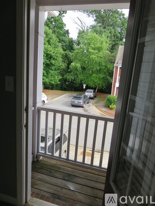 A balcony with a view of a street with cars and trees.
