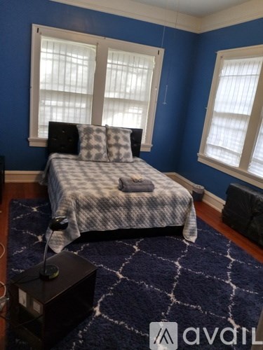 A bedroom with a bed, pillows, and a window.