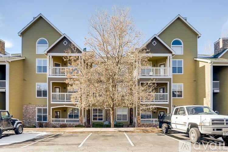 A large apartment complex with a parking lot in front.