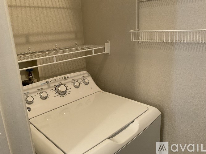 A room with a bed, a chair, a table, and a lamp.