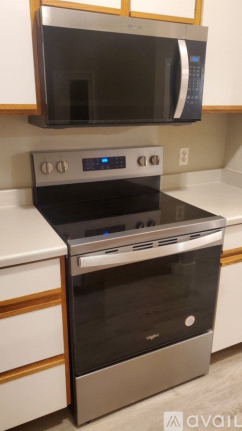 A modern kitchen with a stainless steel oven and microwave above it.