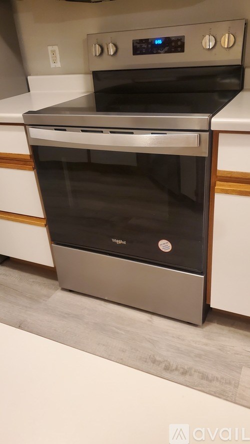 A modern stainless steel oven with a digital control panel is installed in a kitchen.