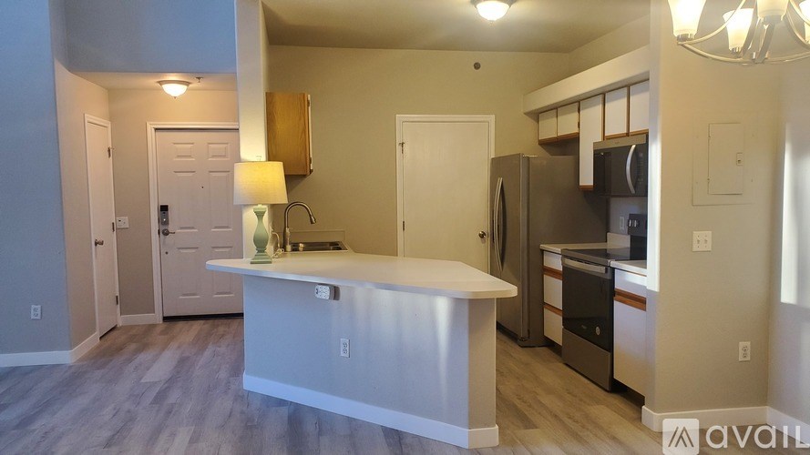 A kitchen with a white island and stainless steel appliances.