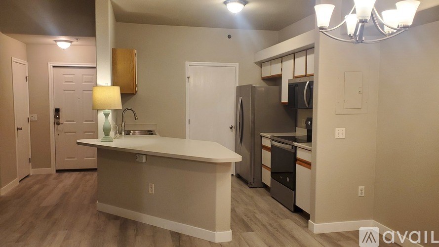 A kitchen with a white counter and a fridge.