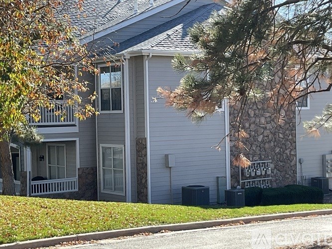 A porch with chairs and a rug.