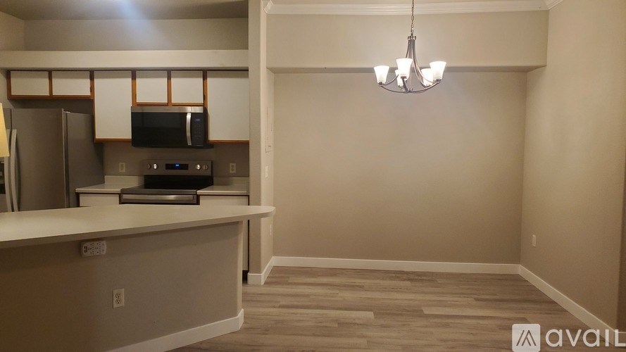 A kitchen with a refrigerator, microwave, and oven.