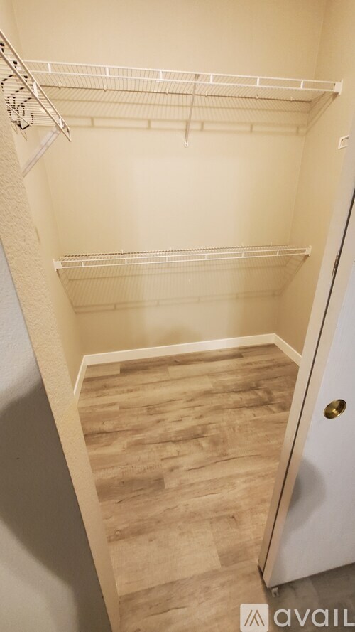 A white refrigerator with a door open and a wooden floor.