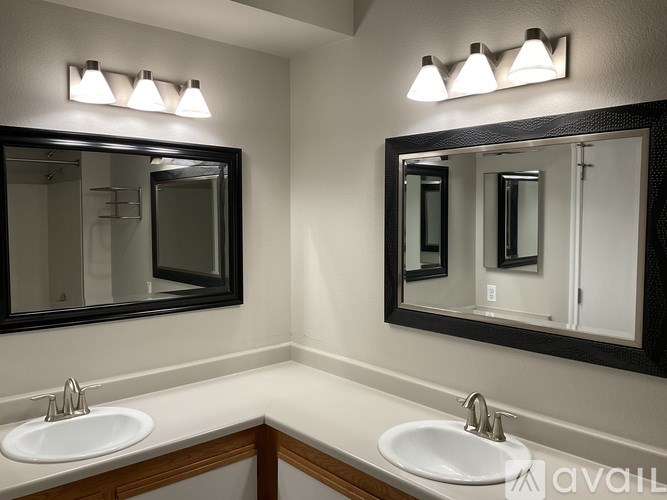 A bathroom with two sinks and mirrors.