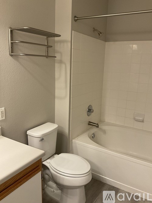 A white toilet sits next to a white bathtub in a bathroom.