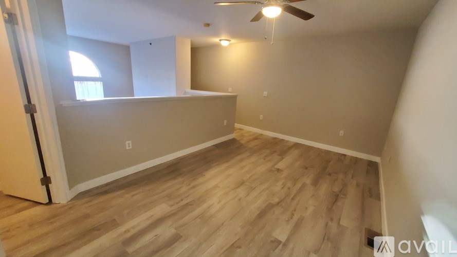 A room with wooden flooring and a ceiling fan.