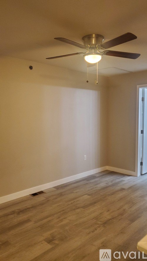A room with a ceiling fan and light fixture.