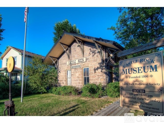 A sign for the Castle Rock Museum stands in front of a building.