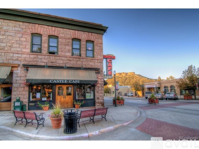 A street view of a cafe with a mountain in the background.