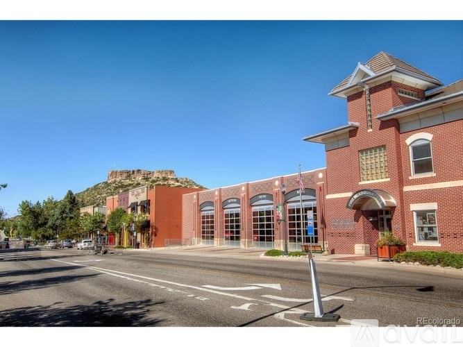 A red brick building with a clock tower and a flag on top.