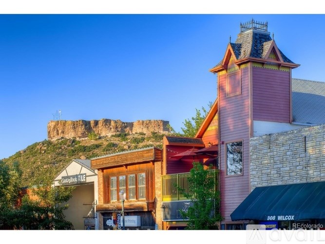 A building with a sign that reads "300 WILCOX" is in the foreground with a mountain in the background.