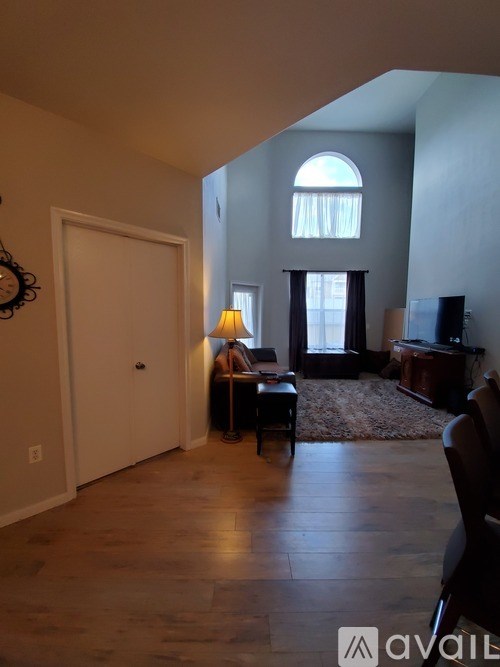 A living room with a couch, chair, and television.